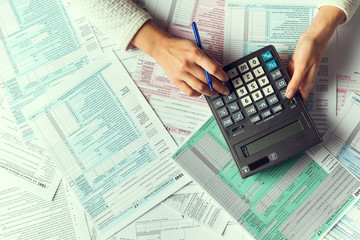 An organized workspace featuring a laptop with financial software, a calculator, and neatly stacked documents, symbolizing efficient bookkeeping for small businesses.